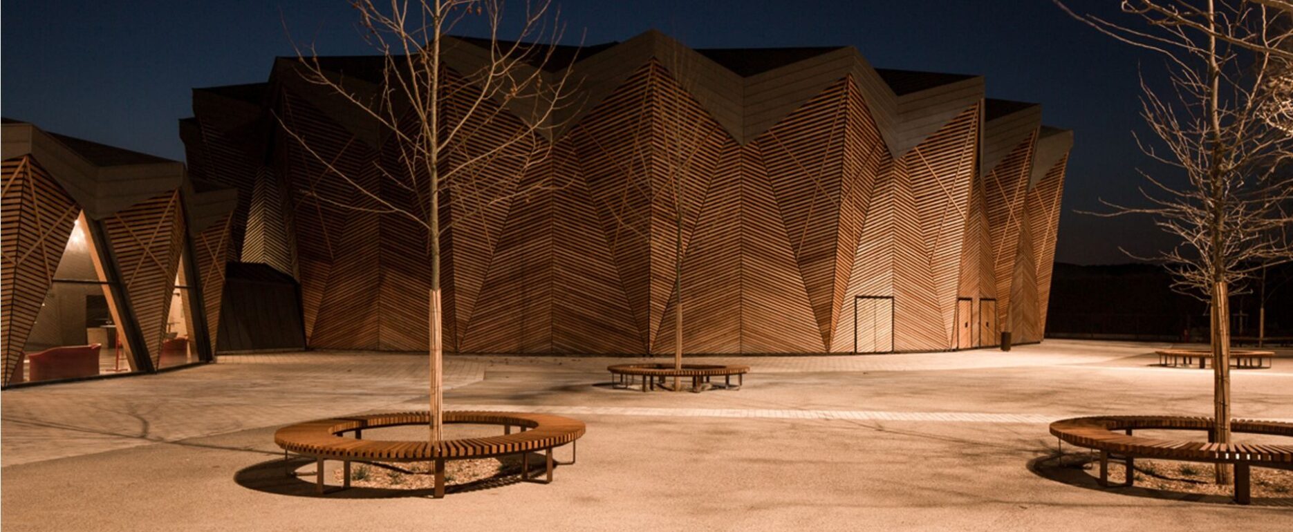 Edificio moderno con diseño geométrico con bancos cobra Disset Urban - Teatro Domaine de Bayssan